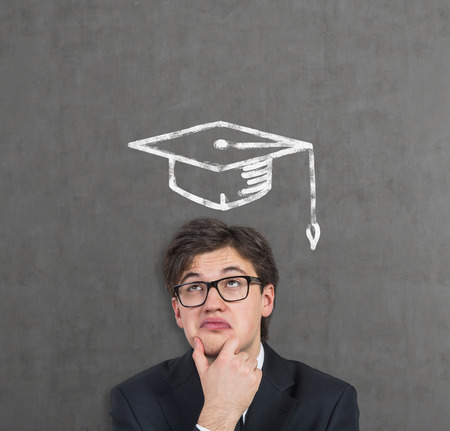 student in drawing bachelor hat on a gray background