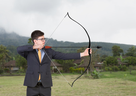 businessman holding a bow on a nature backgroundの写真素材