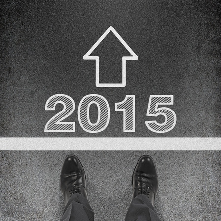 businessman standing on roud with darwing 2015 symbol