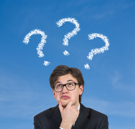 businessman thinking and question mark over head on a blue backgroundの写真素材