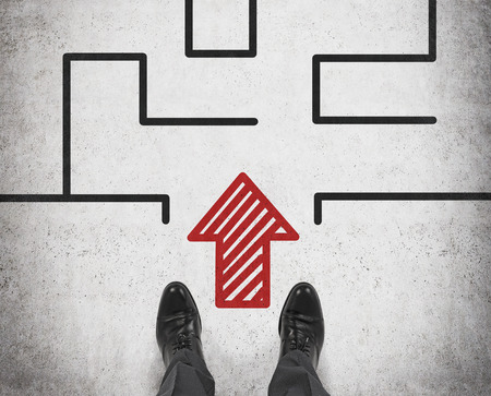 businessman standing on floor with arrow to mazeの写真素材