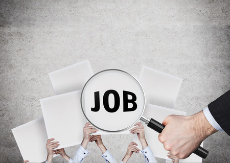 hand holding magnifying glass searching jobの写真素材