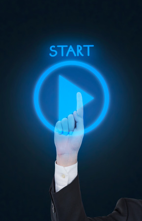 hand pushing play button on black background