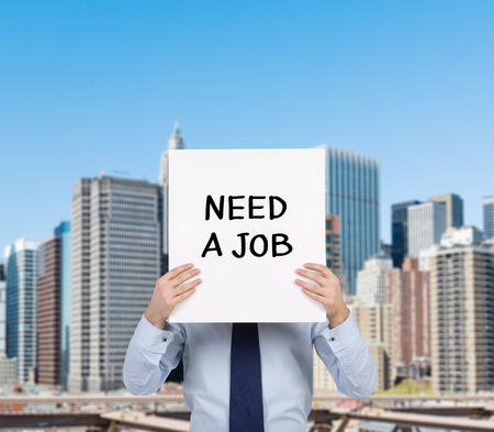 businessman holding placard with need a jobの写真素材
