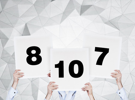 hands holding three poster with number