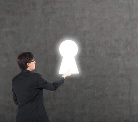 businessman standing on ladder and holding white keyholeの写真素材