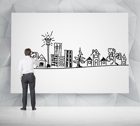 businessman drawing real estate icon on posterの写真素材