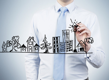 businessman drawing building a on concrete wallの写真素材