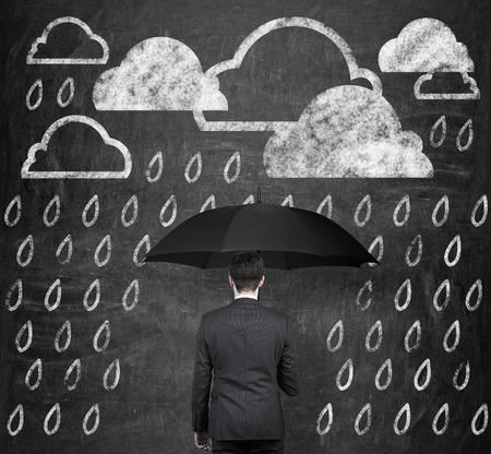 businessman with umbrella and drawing rain on wallの写真素材