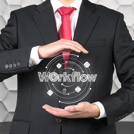 businessman holding workflow scheme in handsの写真素材