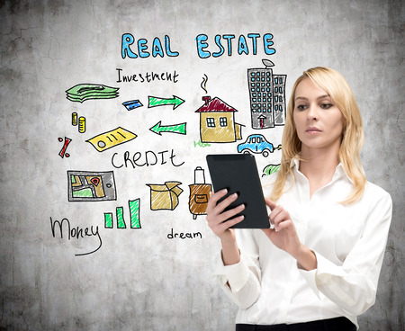 businesswoman with tablet and drawing real estate concept on wallの写真素材