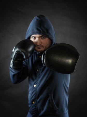 man exercising boxing in gloves on black backgroundの写真素材