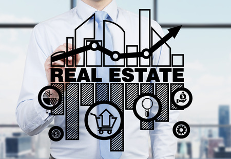 Real estate agent is drawing the chart of the real estate market on the glass screen.の写真素材