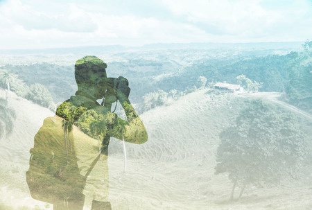 A silhouette of the young tourist who is taking a landscape picture. A concept of travel photos.の写真素材