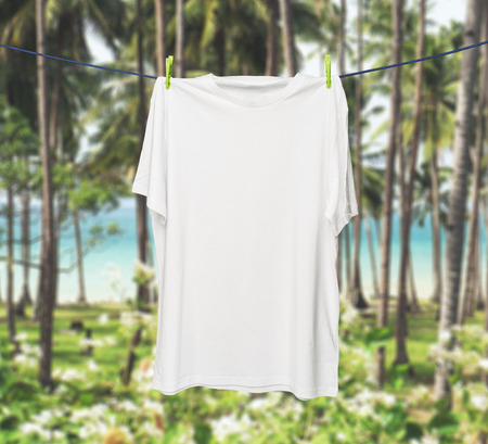 Close up of a white t-shirt on the rope. Tropical jungles and sea in a blur as a background.の写真素材