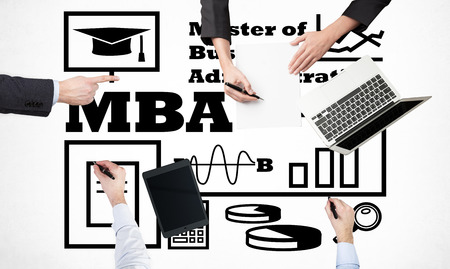 A top view of a brainstorm process. Business students are build start up project as a part of MBA programme. Laptop, tablet and legal pad on the table with drawn flowchart.の写真素材