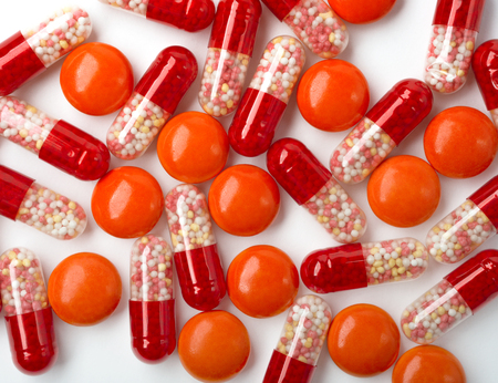 Medical background with red pills and red capsules