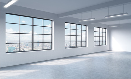 Loft style open space can be used wether office space or residential one. 3D rendering. Huge windows. White walls. New York City view.の写真素材