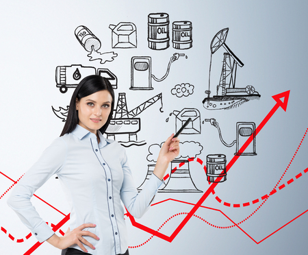 a woman standing in front of the wall thinking about oil production and pollution, illustration of oil industry components on a white wall, red graphs, concept of pollutionの写真素材