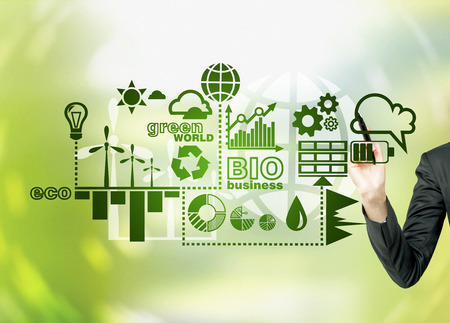A hand painting symbols of alternative energy sources in green. Green background. Concept of clean environment.の写真素材
