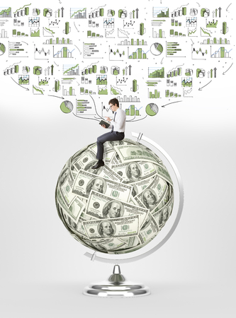Man with book sitting on terrestrial globe made of dollars, graphs and charts over him. Concept of studying.の写真素材