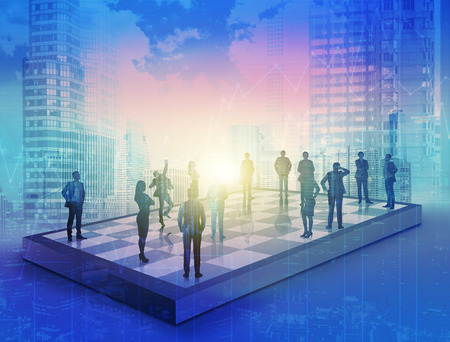 Silhouettes of businesspeole on chess boad through blue hologram. Concept of business development.の写真素材