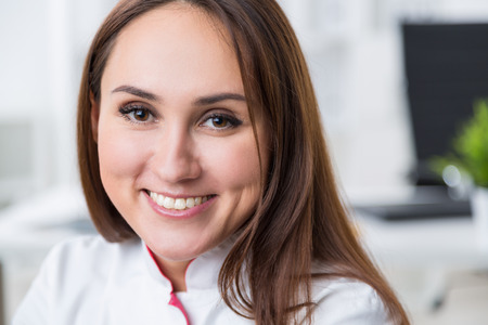 Smiling female doctor with blurry office in the backgroundの写真素材
