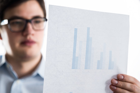 Male in glasses holding paper sheet with business chart
