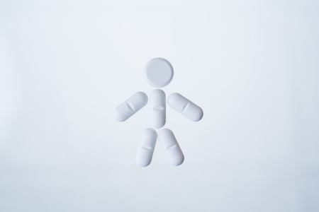 Little man made of pills, round one as head, long as arms and legs. Concept of medicine. 3D renderingの写真素材