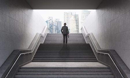 Businessman with briefcase climbing stairs in pedestrian subway, going to the city. Concept of success. New York. 3D Renderingの写真素材