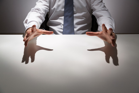 Businessperson at empty office desk about to grab something. Mock upの写真素材