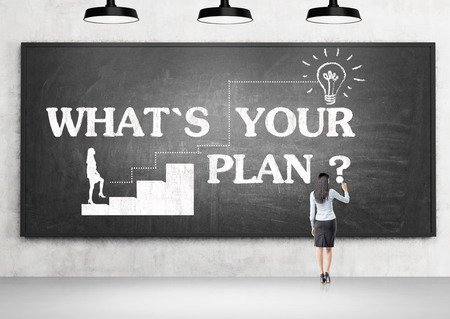 Planning concept with businesswoman drawing on blackboard in concrete roomの写真素材