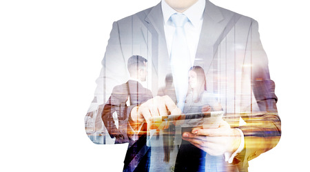Businessman using pad with people shaking hands in the background. Double exposureの写真素材