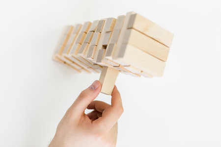 Topview of male hand playing with wooden blocks on white backgroundの写真素材