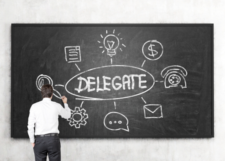 Businessman drawing delegating sketch on chalkboardの写真素材