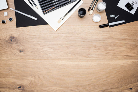 Top view of wooden desktop with drawing tools and stationery items. Mock up