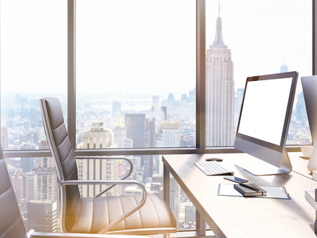 Closeup of office workplace with blank computer screen and New York city view. Mock up, 3D Renderingの写真素材