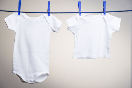 Infant bodysuit and shirt hanging on a clothesline. Mock upの写真素材