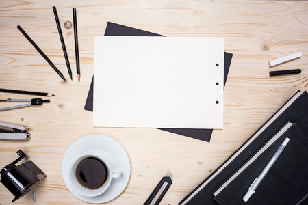 Top view of wooden table with blank paper sheet, smart phone and various stationery items. Mock upの写真素材
