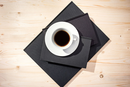 Top view of coffee cup on closed notepadsの写真素材