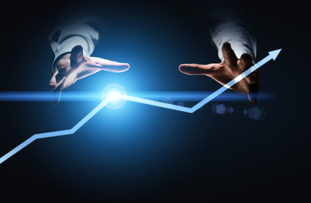 Financial growth concept with businessman hands willing to grab illuminated arrow pointed upwardsの写真素材