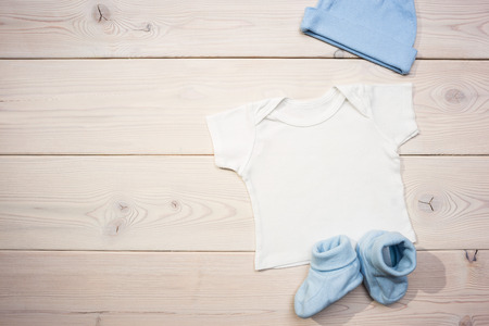 Blue baby apparel on wooden table. Mock upの写真素材