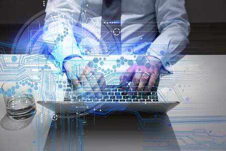 Closeup of businessman using laptop with abstract digital pattern at office desk with glass of water