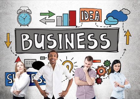 Business idea, success and teamwork concept with businesspeople of different races standing against concrete wall with colorful sketchの写真素材