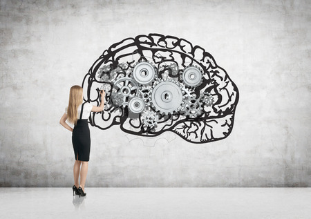 Businesswoman drawing abstract brain with metal gears on concrete wall in room. Brainstorming...