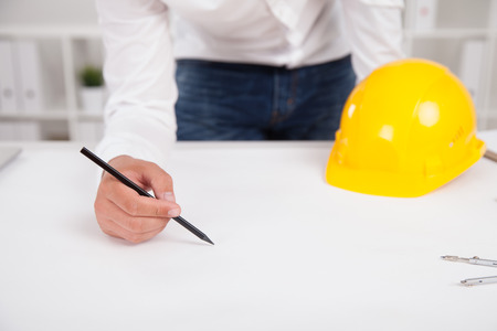 Architect in white shirt and blue jeans at work designing new city area. Concept of contemporary designの写真素材