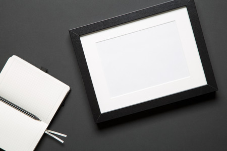 Top view of photo frame, an open notebook and a sharp pencil. Concept of sketching and making a work...