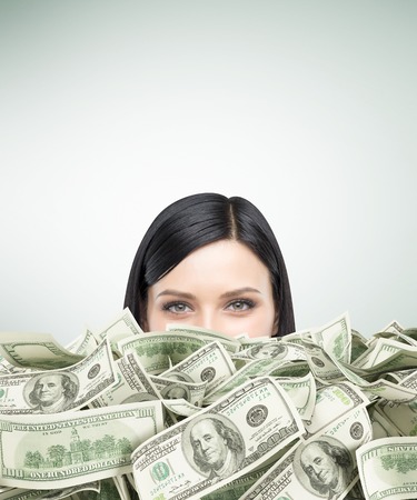 Close up of girl's head with black hair piled up in cash. Concept of being too rich. Mock upの写真素材