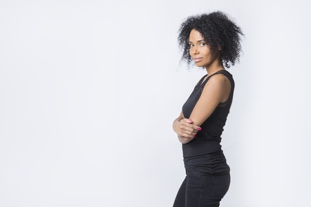 Side view of African American woman looking at the camera and standing with her arms crossed. Concept of strong independent woman. Mock upの写真素材
