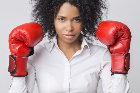 Centered African American girl with red boxing gloves wearing formal clothes and looking at the viewer.の写真素材